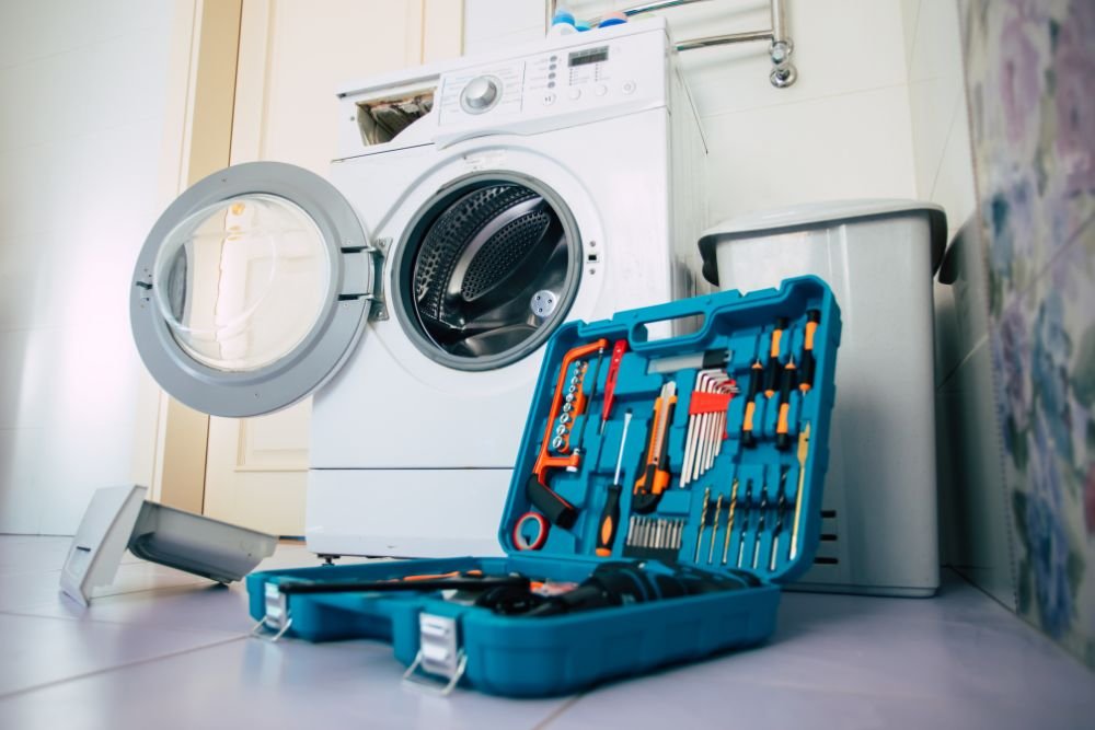 A washing machine and tools arranged in a room, illustrating laundry appliance repair services offered in Miami, FL.
