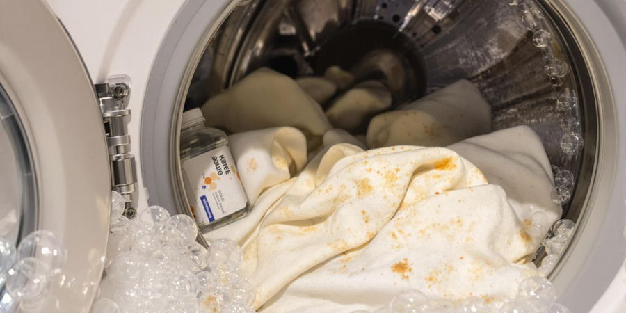  A white cloth resting inside a washing machine, ready for a wash cycle to begin.
